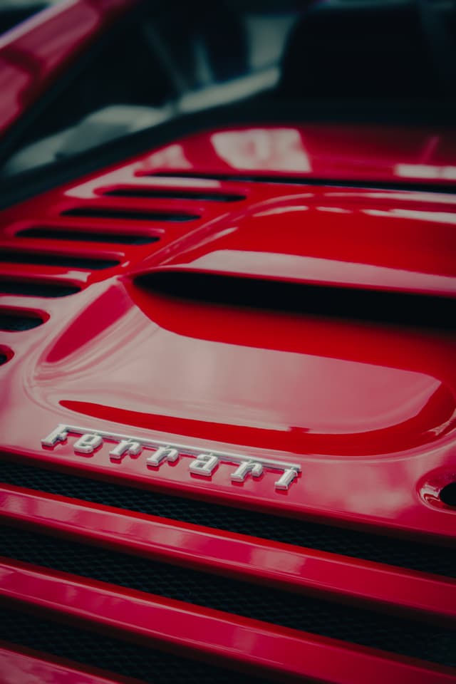 A close-up of a red Ferrari with the logo prominently displayed on the car's body
