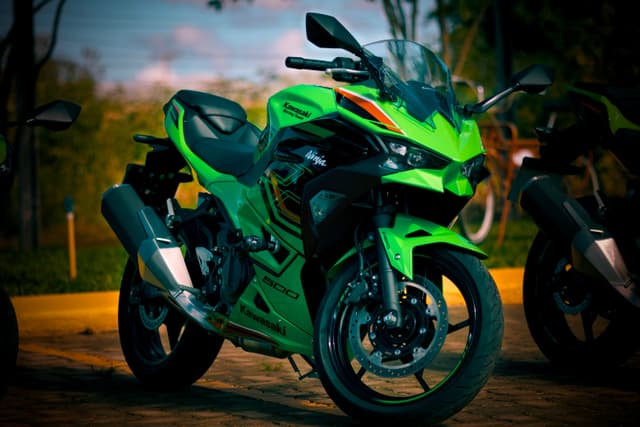 A vibrant green sport motorcycle parked outdoors, featuring sleek aerodynamic design and black accents
